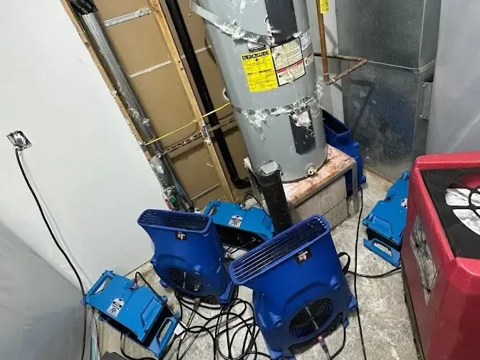 Drying equipment set inside a small water heater closet after a tank leak
