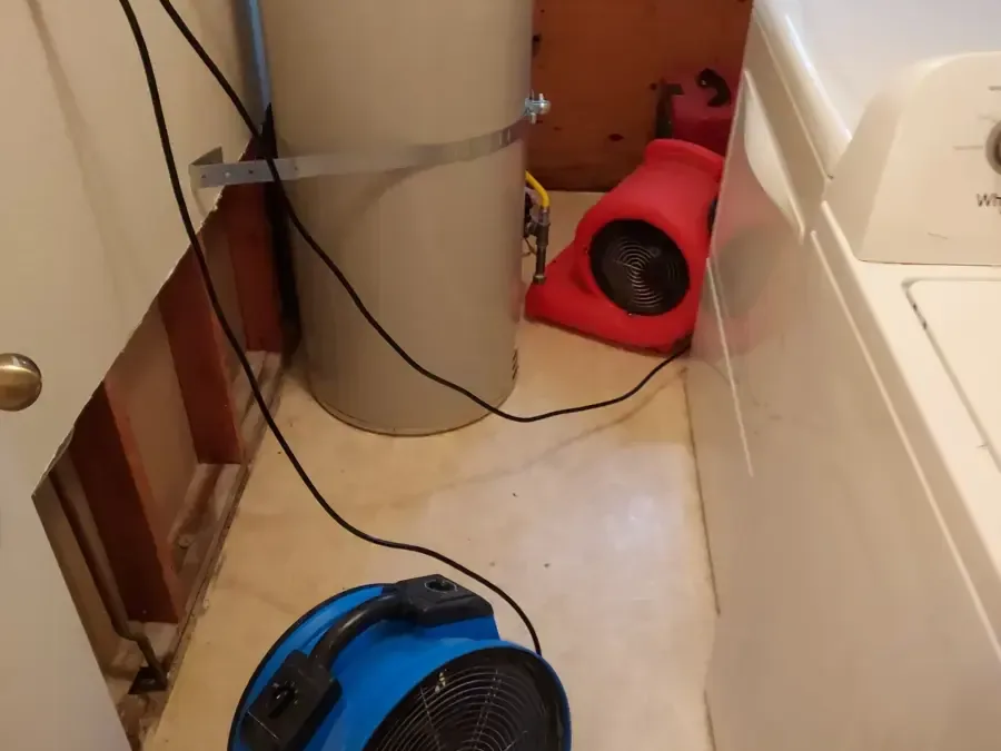 Laundry area with the wall opened behind the washer and air movers running