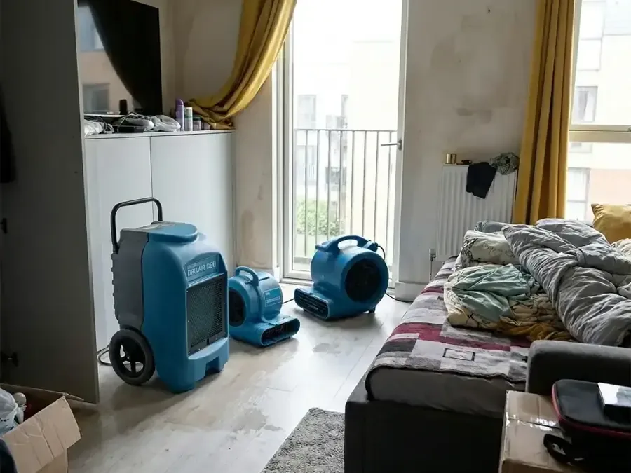 Bedroom with a dehumidifier and air movers drying the carpet after a leak