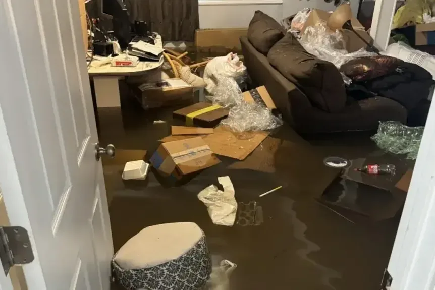 Floodwater spread across a living room floor before extraction starts