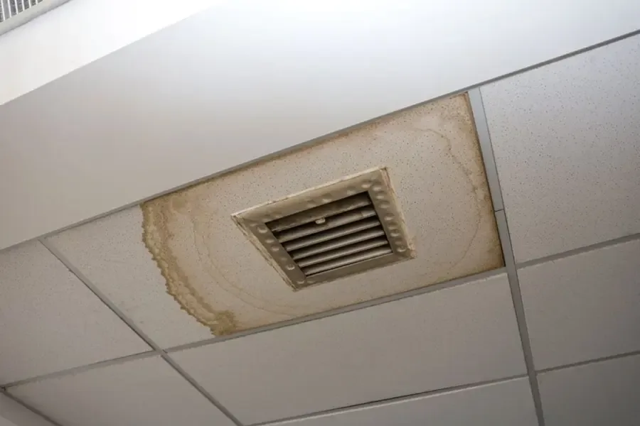 Ceiling stain left by an overflowing AC condensate pan above